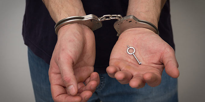 Expunge or seal an arrest record in Tampa, Florida. Male with handcuffs on.